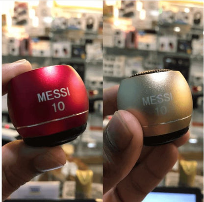 Two small cylindrical speakers, one red and one gold, with 'Messi 10' branding held in a hand.